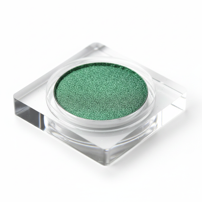 Emerald green eyeshadow pan 45-degree side angle close-up showing powder depth and shimmer texture
