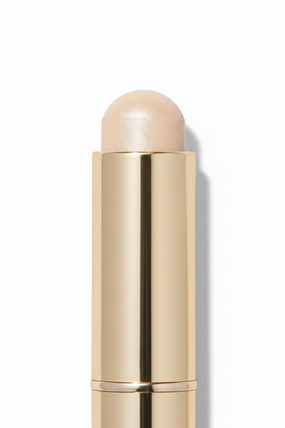 Gold twist-up highlighter stick 45-degree close-up showing dome tip shimmer texture